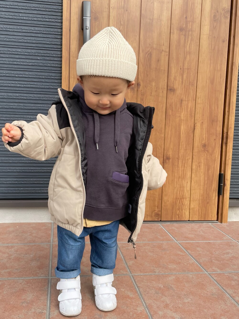 パープル系のパーカー、イエロー系のシャツ/ブラウス、ブルー系のデニムパンツを着用したキッズの冬コーディネートの2枚目の写真