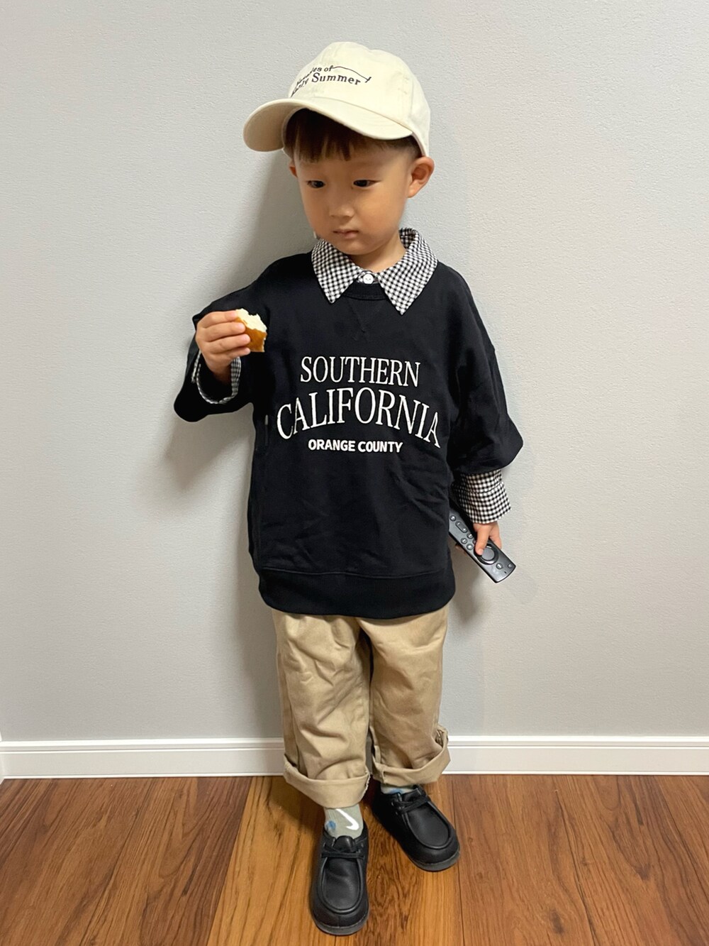 ブラック系のスウェット、ブラック系のシャツ/ブラウス、ベージュ系のチノパンツを着用したキッズの秋コーディネートの3枚目の写真