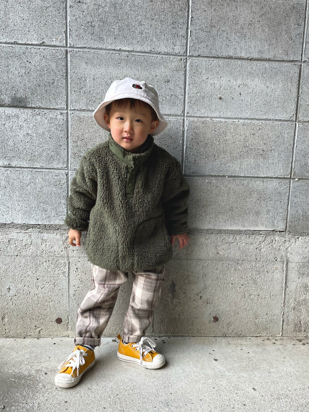 グリーン系のブルゾン、イエロー系のスニーカー、ベージュ系のその他パンツを着用したキッズの春コーディネートの2枚目の写真