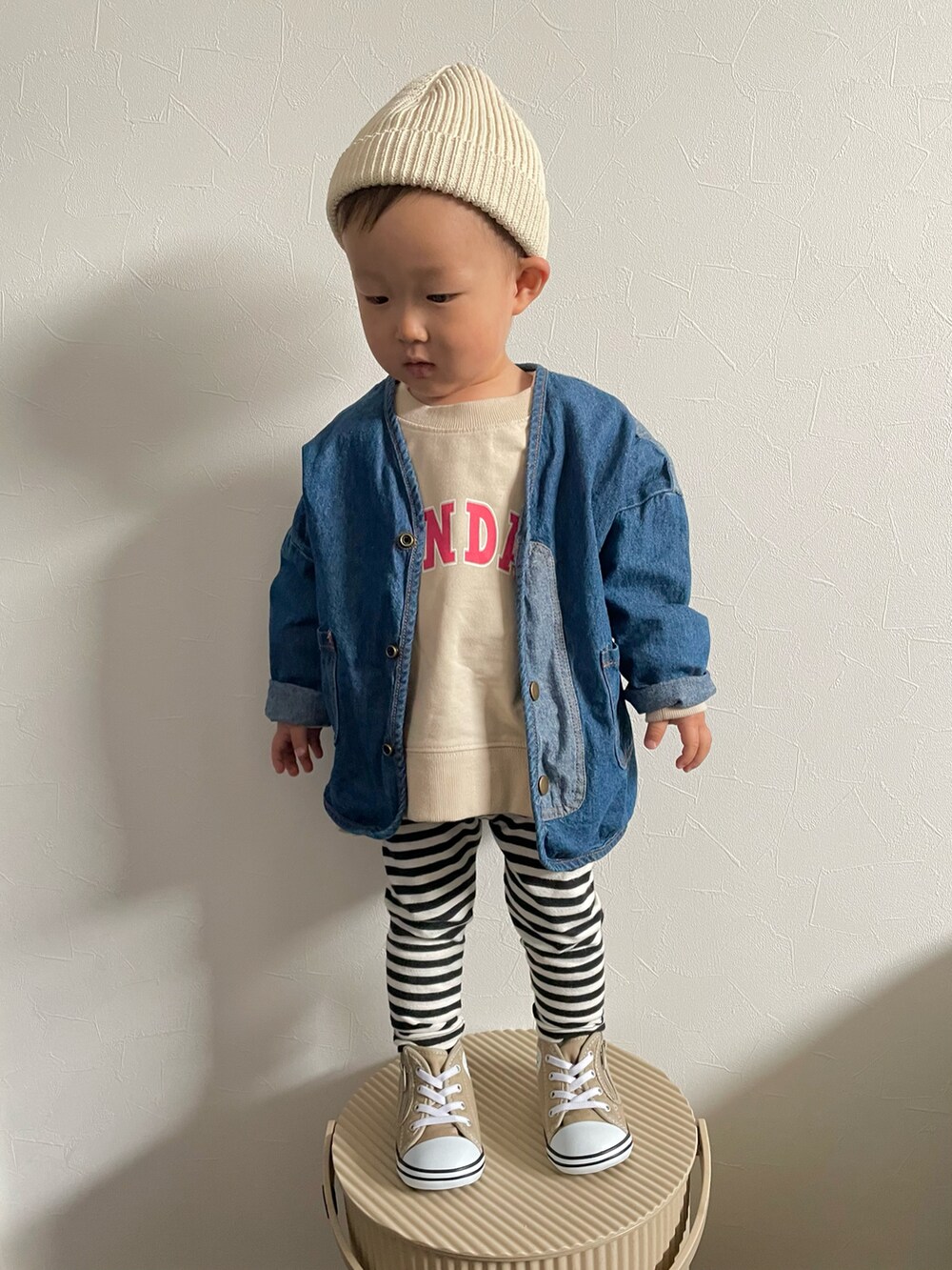 ベージュ系のスウェット、ブルー系のデニムジャケット、ベージュ系のスニーカーを着用したキッズの春コーディネートの4枚目の写真