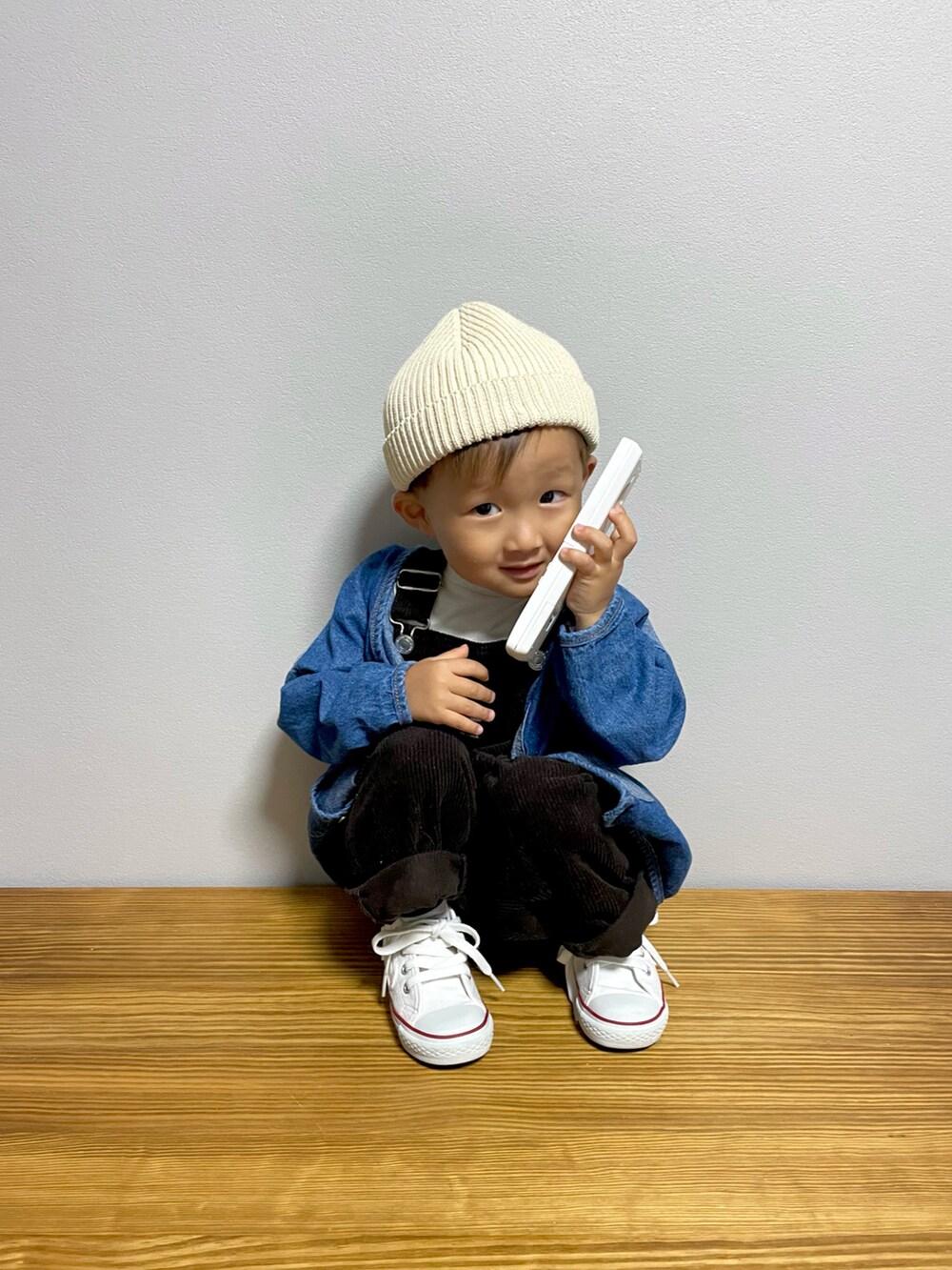 ブルー系のデニムジャケット、グレー系のサロペット/オーバーオール、ホワイト系のスニーカーを着用したキッズの秋コーディネートの4枚目の写真