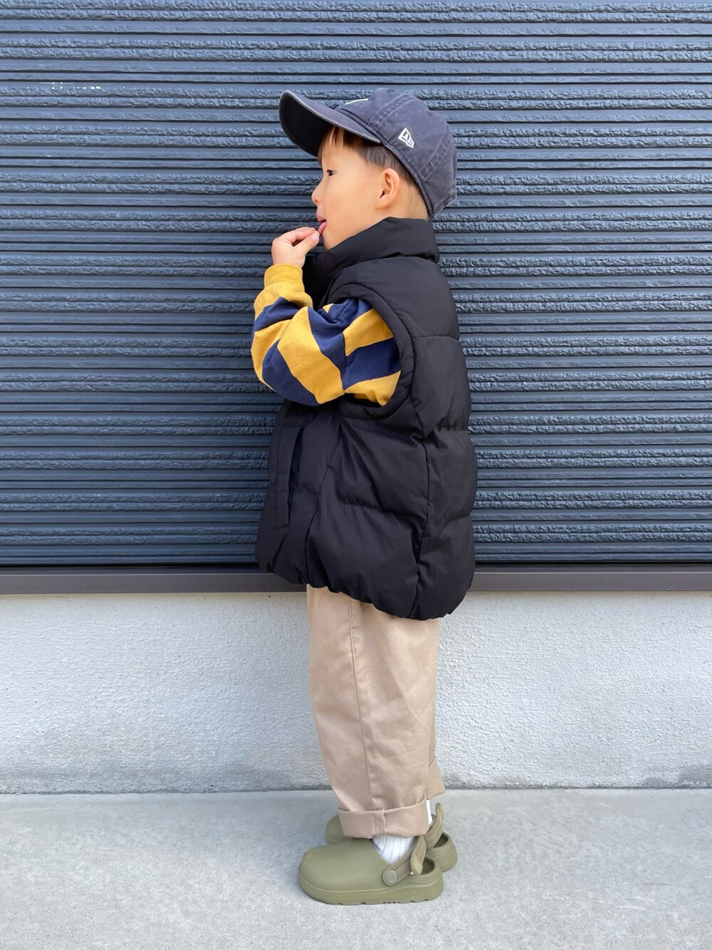 ブラック系のブルゾン、イエロー系のTシャツ/カットソー、ベージュ系のチノパンツを着用したキッズの秋コーディネートの2枚目の写真