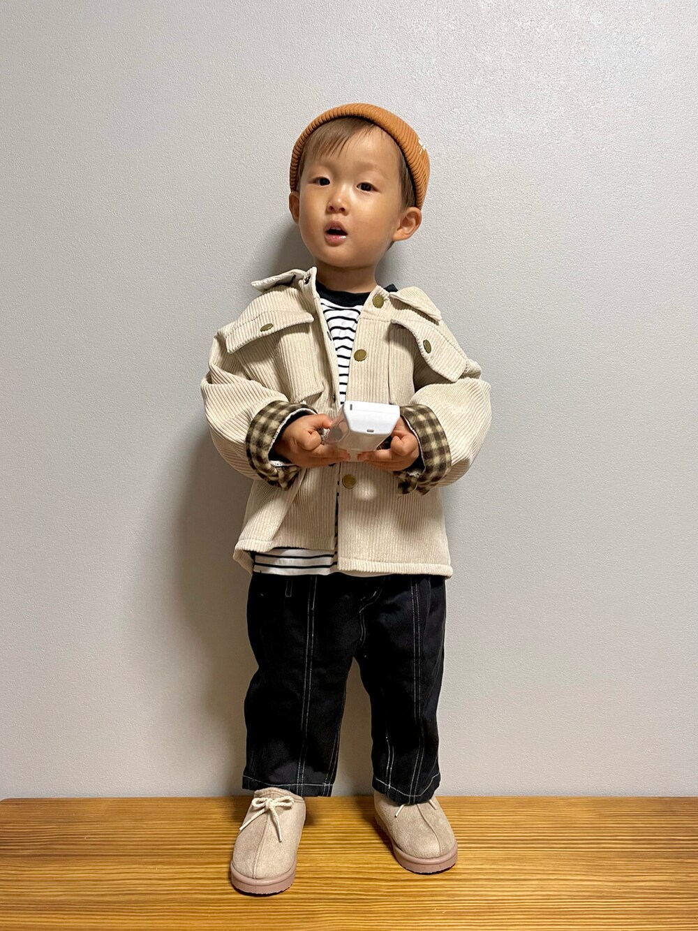 ブラック系のTシャツ/カットソー、ベージュ系のジャケット/アウター、ブラック系のパンツを着用したキッズの秋コーディネートの3枚目の写真