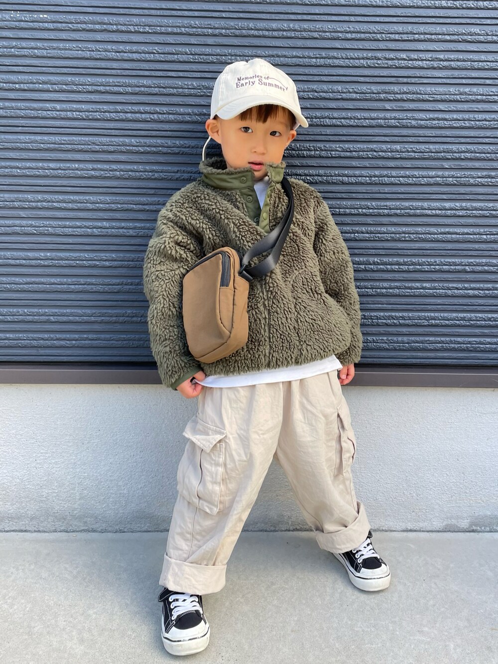 グリーン系のブルゾン、ブラウン系のショルダーバッグ、ベージュ系のその他パンツを着用したキッズの秋コーディネートの2枚目の写真