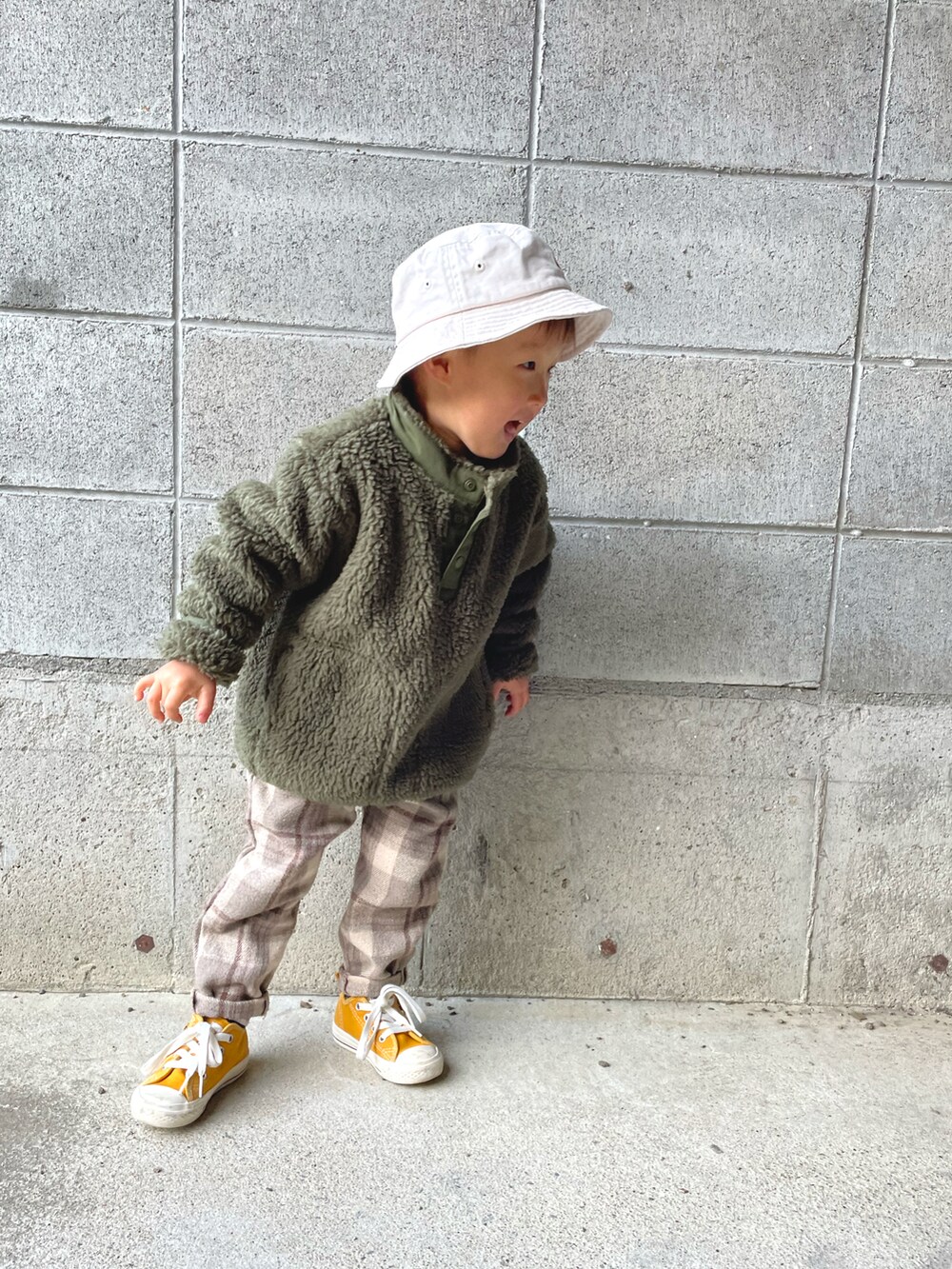 グリーン系のブルゾン、イエロー系のスニーカー、ベージュ系のその他パンツを着用したキッズの春コーディネートの3枚目の写真