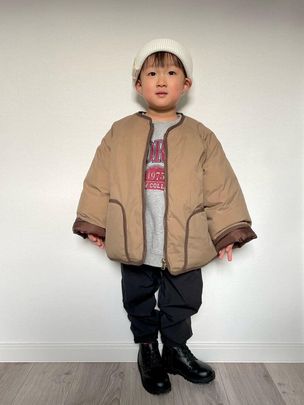 ブラウン系のノーカラージャケット、グレー系のスウェット、ブラック系のその他パンツを着用したキッズの冬コーディネートの2枚目の写真