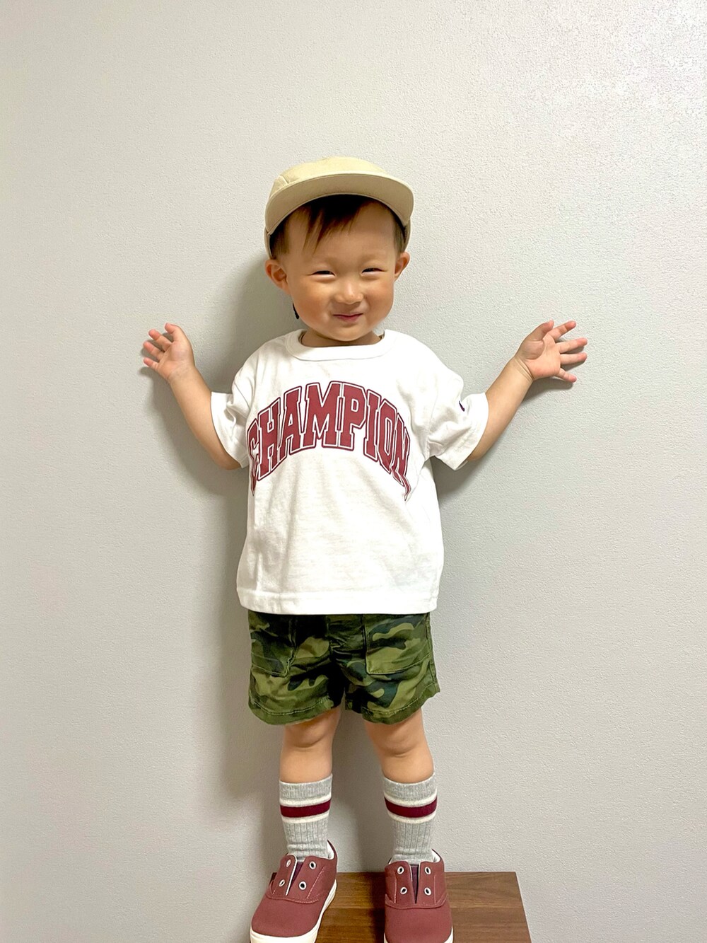 グリーン系のカーゴパンツ、レッド系のスニーカー、ベージュ系のキャップを着用したキッズの春コーディネートの5枚目の写真