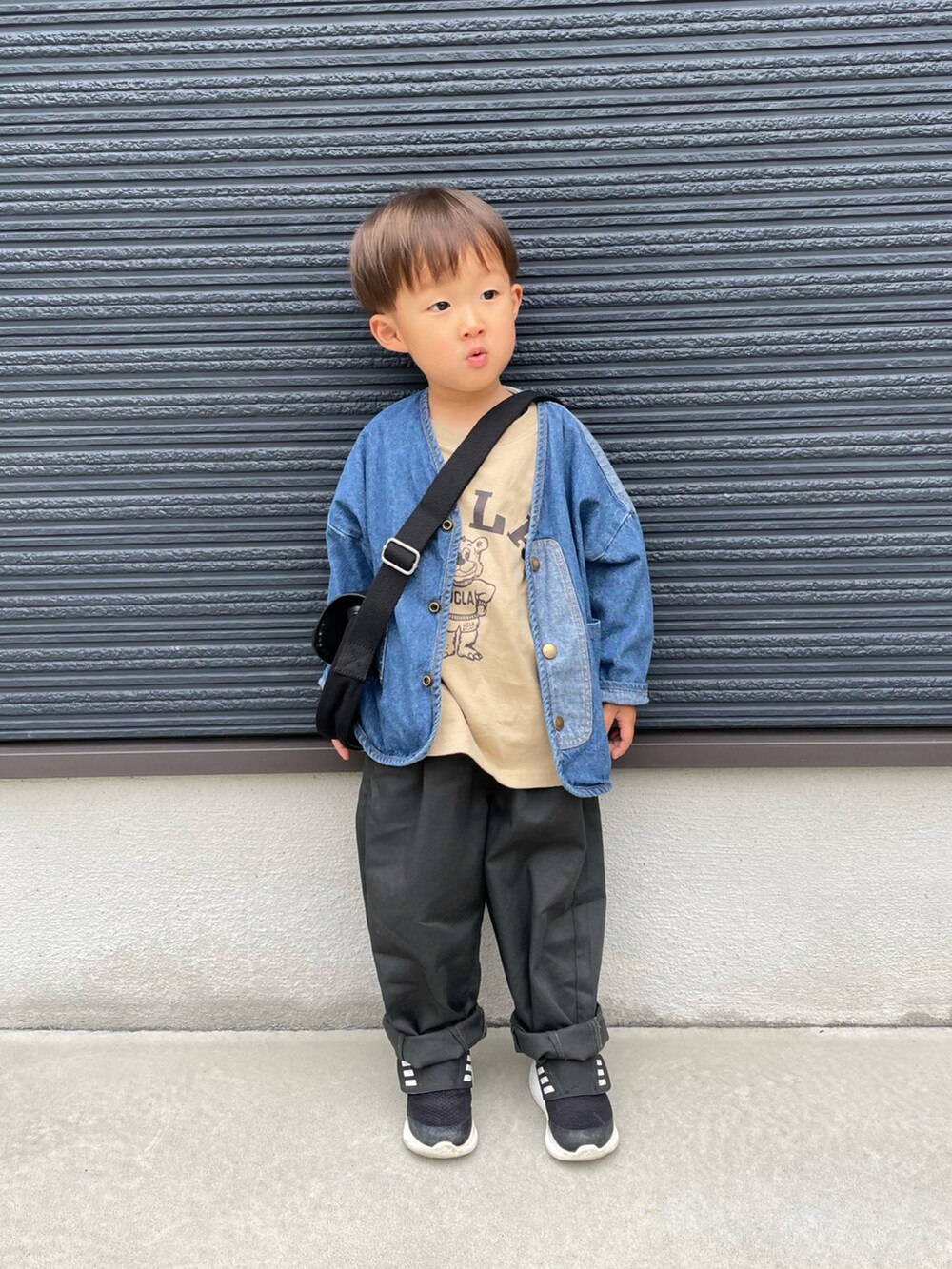 ベージュ系のTシャツ/カットソー、ブルー系のデニムジャケット、ブラック系のショルダーバッグを着用したキッズの春コーディネートの3枚目の写真