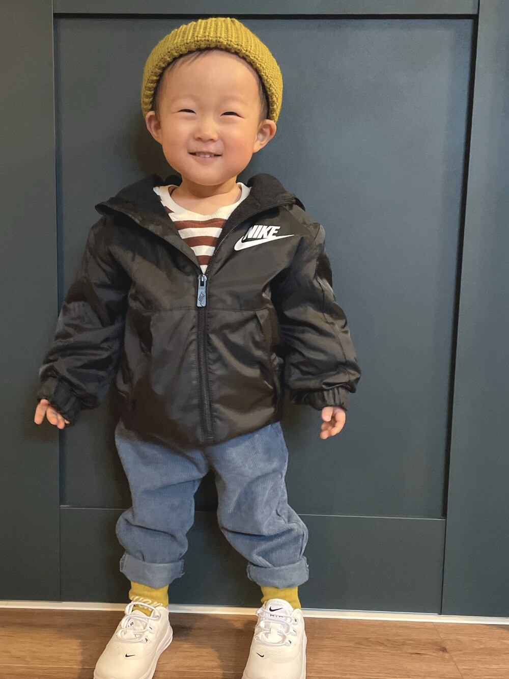 ブラック系のナイロンジャケット、ブルー系のその他パンツ、イエロー系のニットキャップ/ビーニーを着用したキッズの冬コーディネートの2枚目の写真