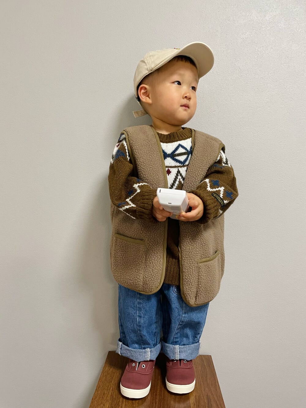 グリーン系のその他アウター、ブラウン系のニット/セーター、ブルー系のデニムパンツを着用したキッズの冬コーディネートの2枚目の写真