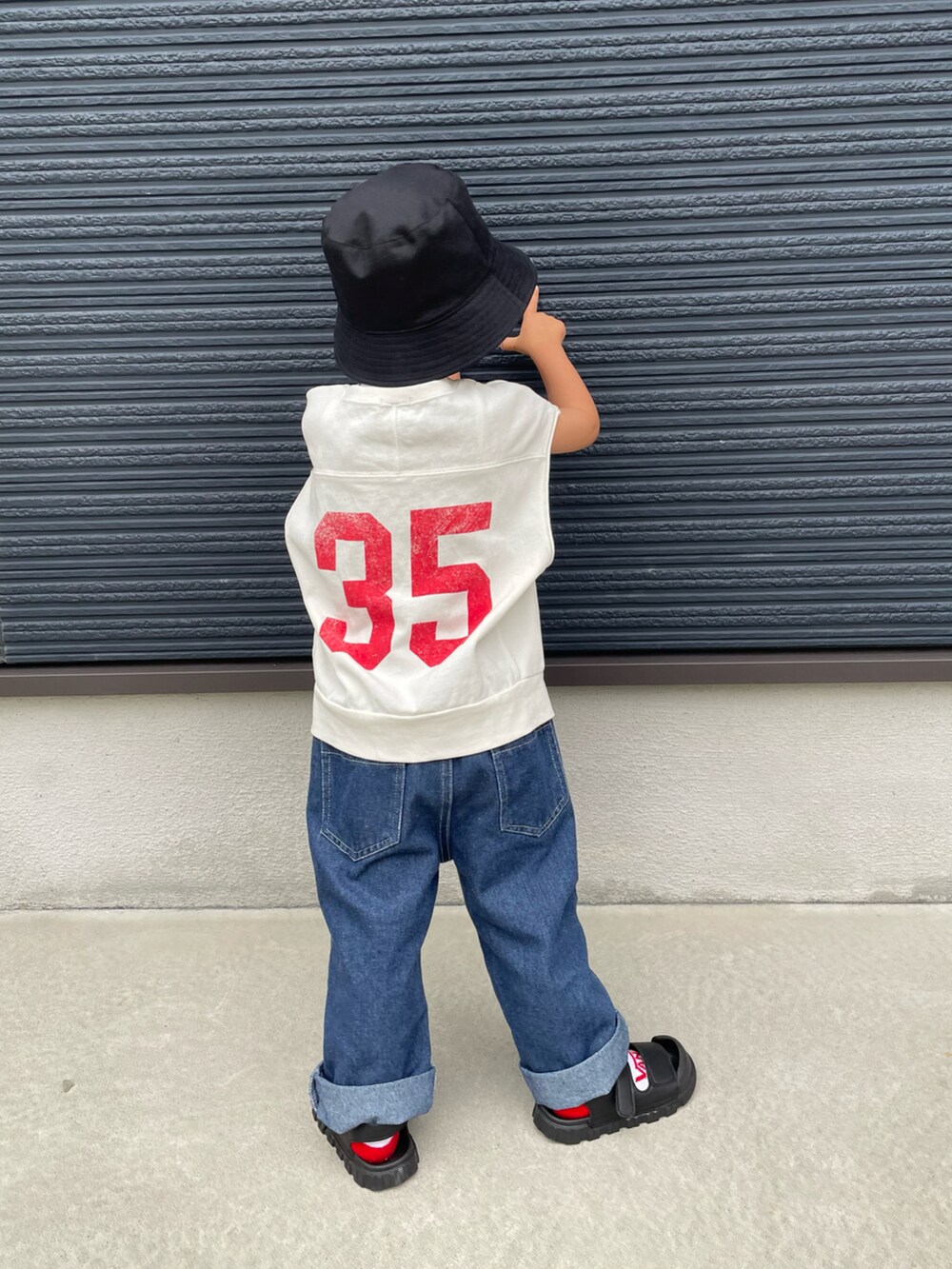 ホワイト系のTシャツ/カットソー、ブルー系のデニムパンツ、ブラック系のサンダルを着用したキッズの春コーディネートの5枚目の写真