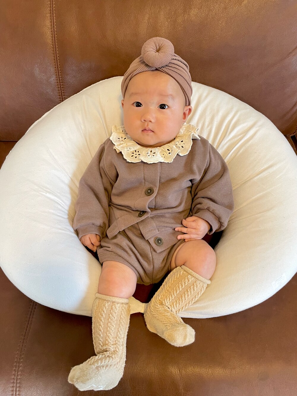 ブラウン系のその他ベビーウェア、ホワイト系のロンパース、ブラウン系のヘアバンドを着用したキッズの秋コーディネートの2枚目の写真