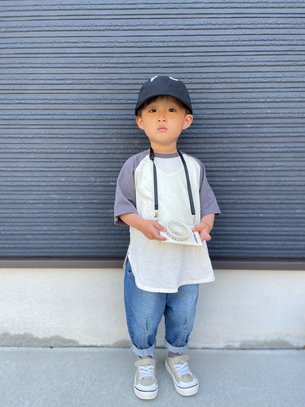 グレー系のTシャツ/カットソー、ブルー系のデニムパンツ、ベージュ系のスニーカーを着用したキッズの春コーディネートの3枚目の写真