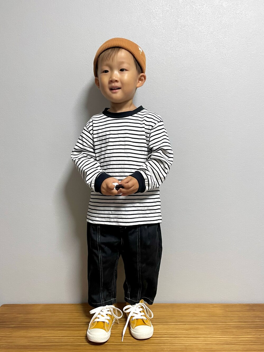 ブラック系のTシャツ/カットソー、ブラック系のパンツ、イエロー系のスニーカーを着用したキッズの秋コーディネートの2枚目の写真