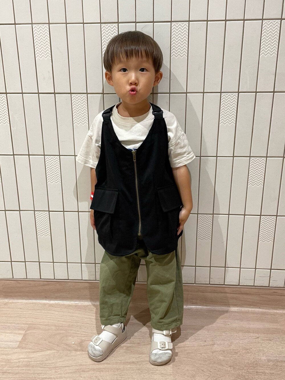 ホワイト系のTシャツ/カットソー、グリーン系のその他パンツ、ベージュ系のサンダルを着用したキッズの秋コーディネートの2枚目の写真