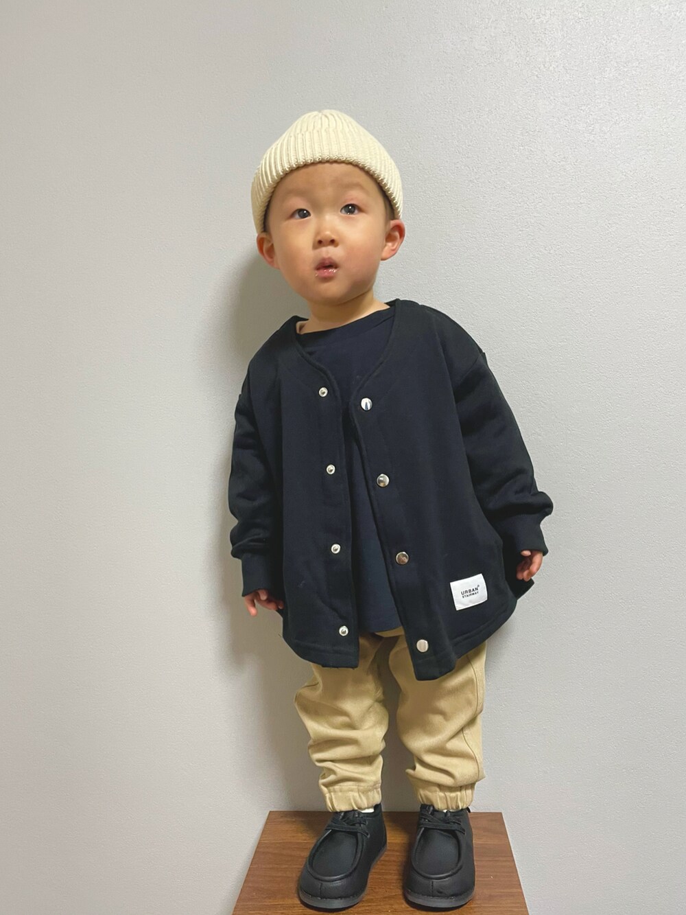 ブラック系のTシャツ/カットソー、ブラック系のノーカラージャケット、ベージュ系のパンツを着用したキッズの冬コーディネートの3枚目の写真