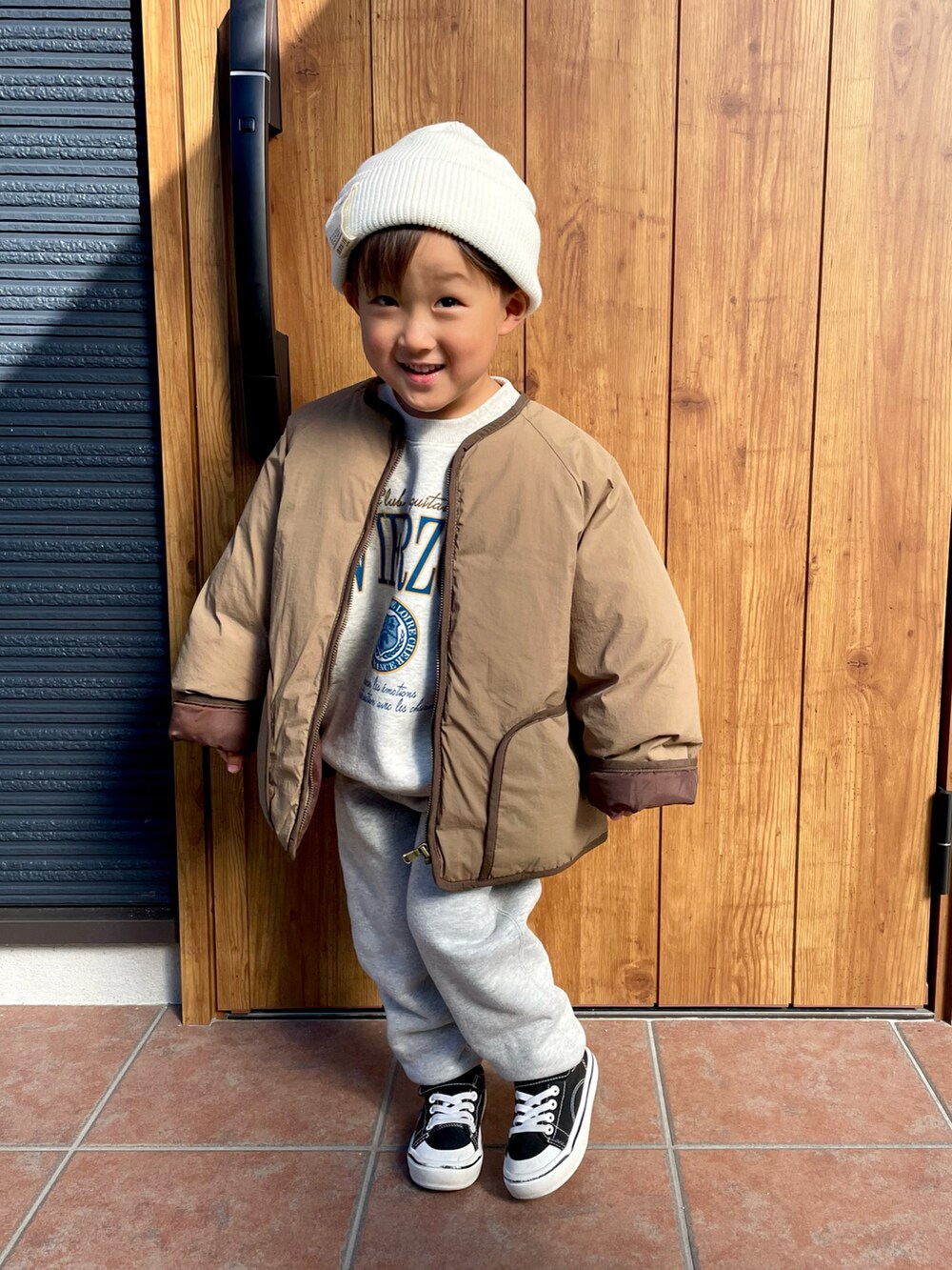 グレー系のスウェット、ブラウン系のノーカラージャケット、グレー系のスウェットパンツを着用したキッズの冬コーディネートの4枚目の写真