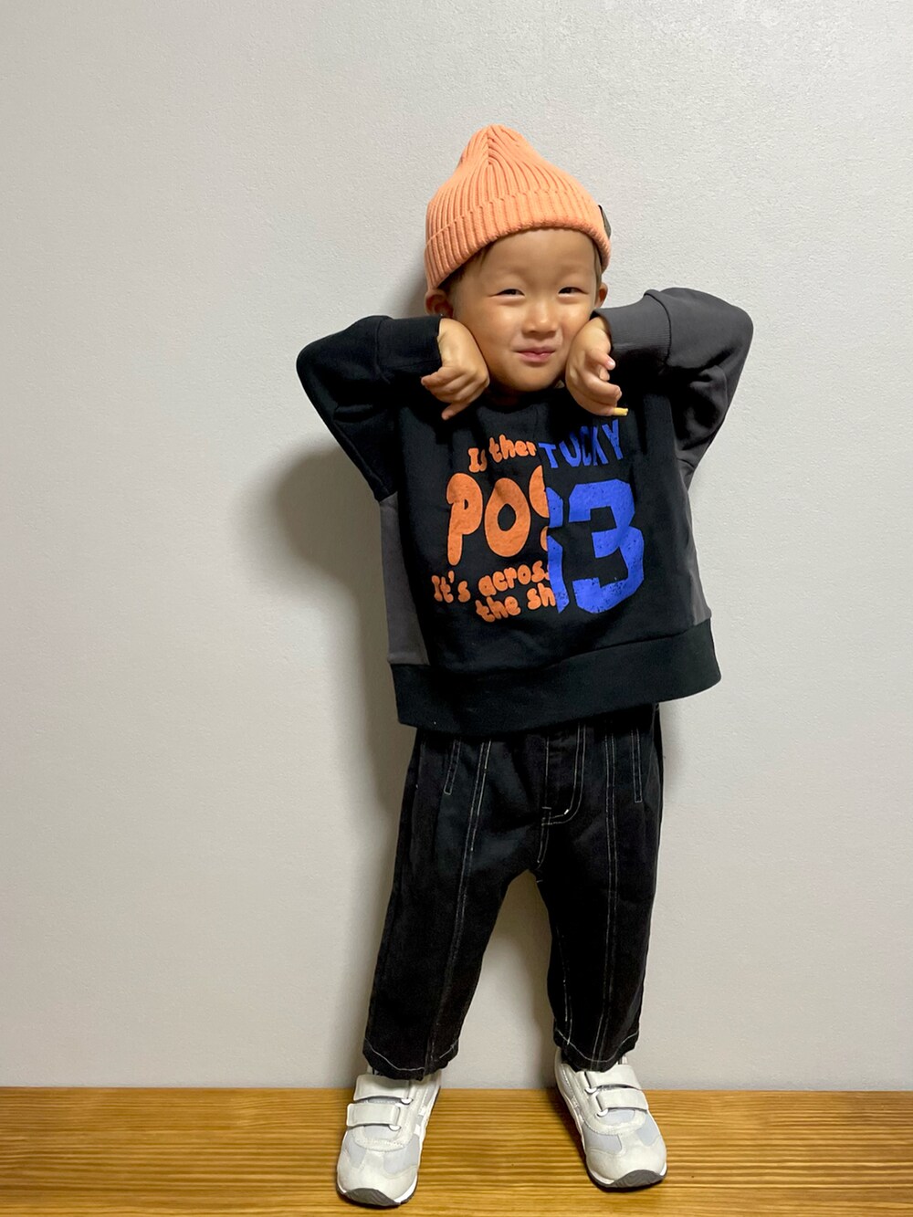 ブラック系のスウェット、ブラック系のパンツ、グレー系のスニーカーを着用したキッズの秋コーディネートの3枚目の写真