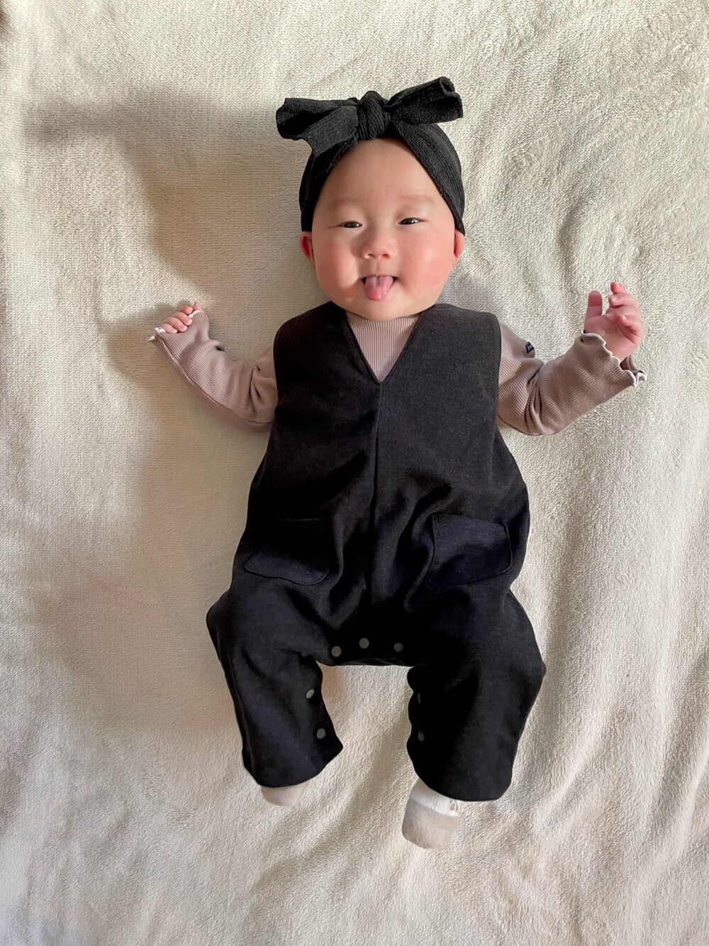 ブラック系のサロペット/オーバーオール、ブラウン系のロンパースを着用したキッズの冬コーディネートの2枚目の写真