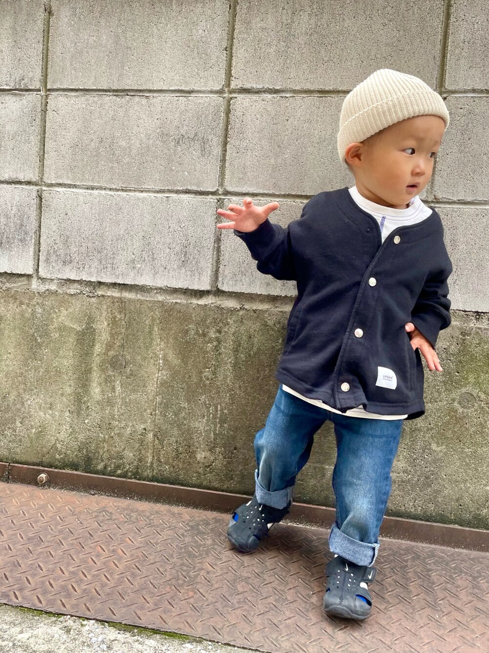 ブラック系のノーカラージャケット、ホワイト系のTシャツ/カットソー、ブルー系のデニムパンツを着用したキッズの春コーディネートの2枚目の写真