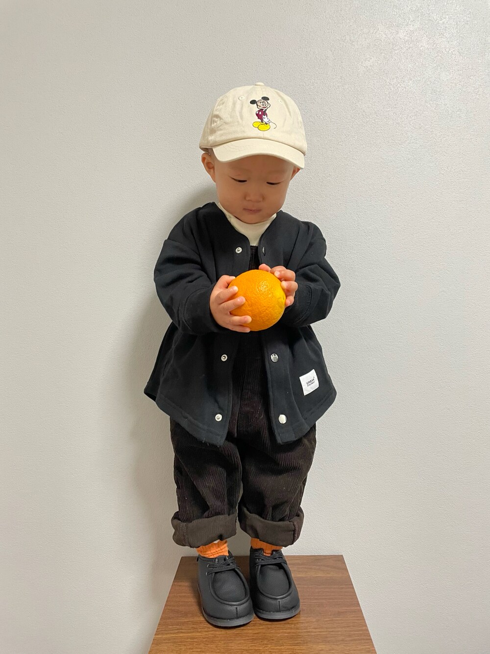 ホワイト系のTシャツ/カットソー、ブラック系のノーカラージャケット、グレー系のサロペット/オーバーオールを着用したキッズの冬コーディネートの2枚目の写真