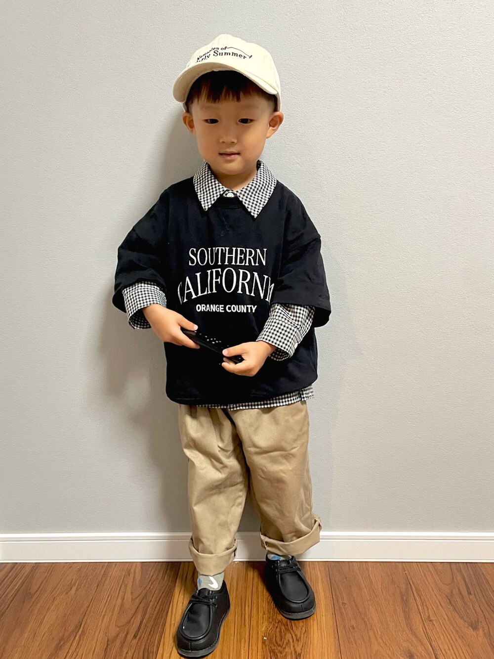 ブラック系のスウェット、ブラック系のシャツ/ブラウス、ベージュ系のチノパンツを着用したキッズの秋コーディネートの4枚目の写真