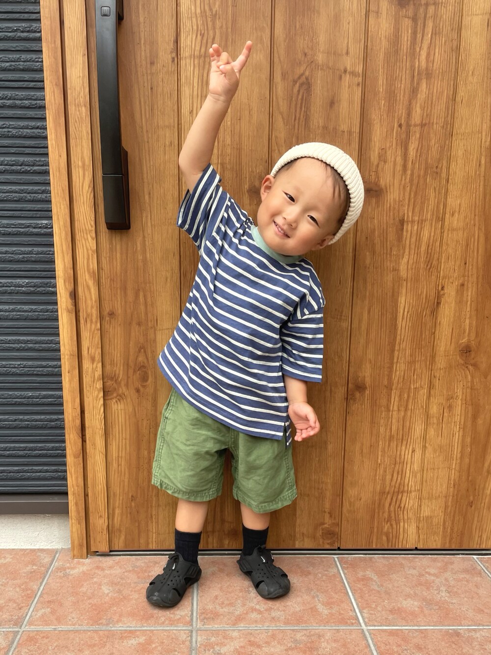 ブルー系のTシャツ/カットソー、グリーン系のパンツ、ブラック系のサンダルを着用したキッズの夏コーディネートの2枚目の写真