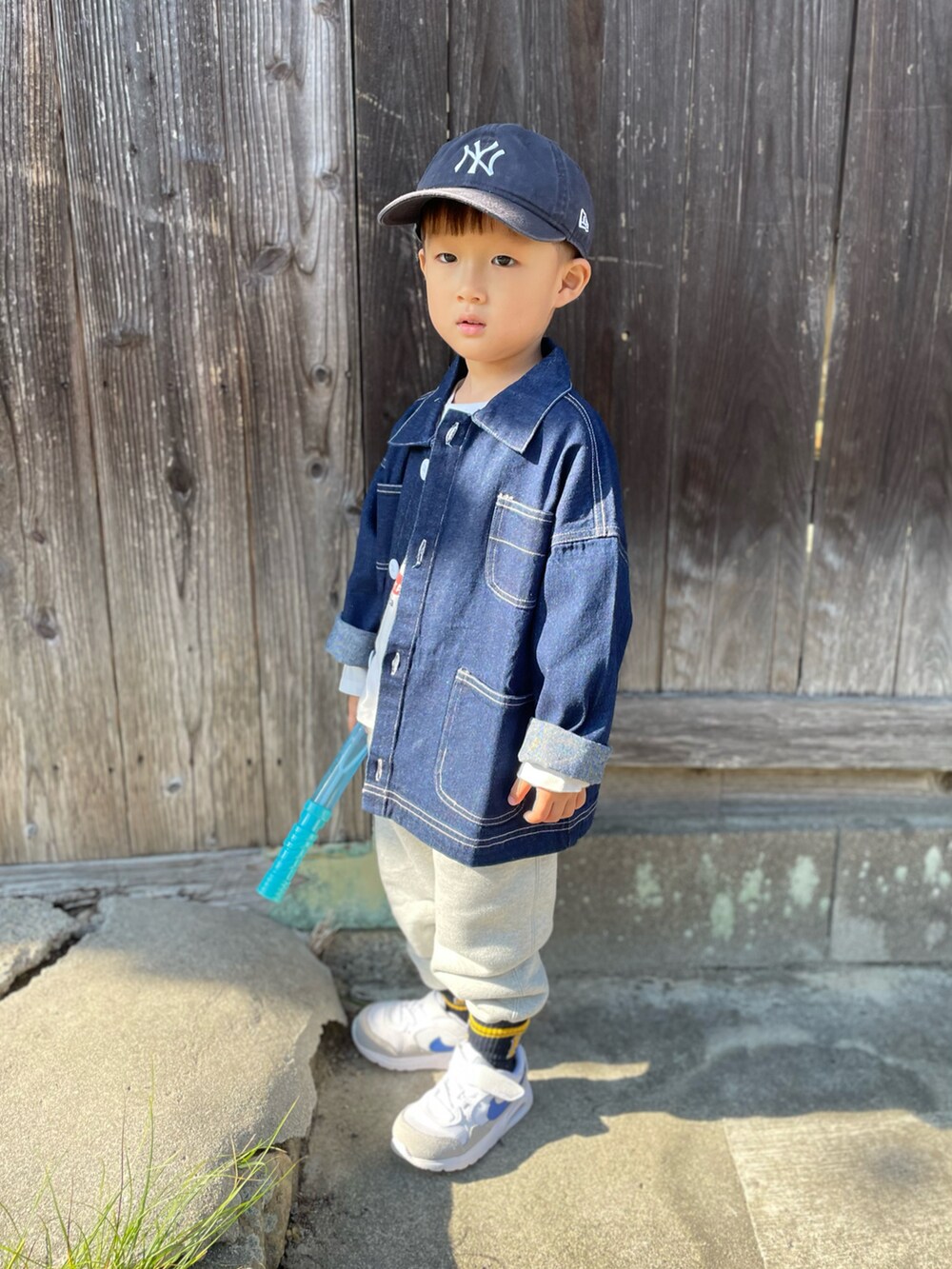ホワイト系のTシャツ/カットソー、ブルー系のデニムジャケット、グレー系のスウェットパンツを着用したキッズの秋コーディネートの3枚目の写真