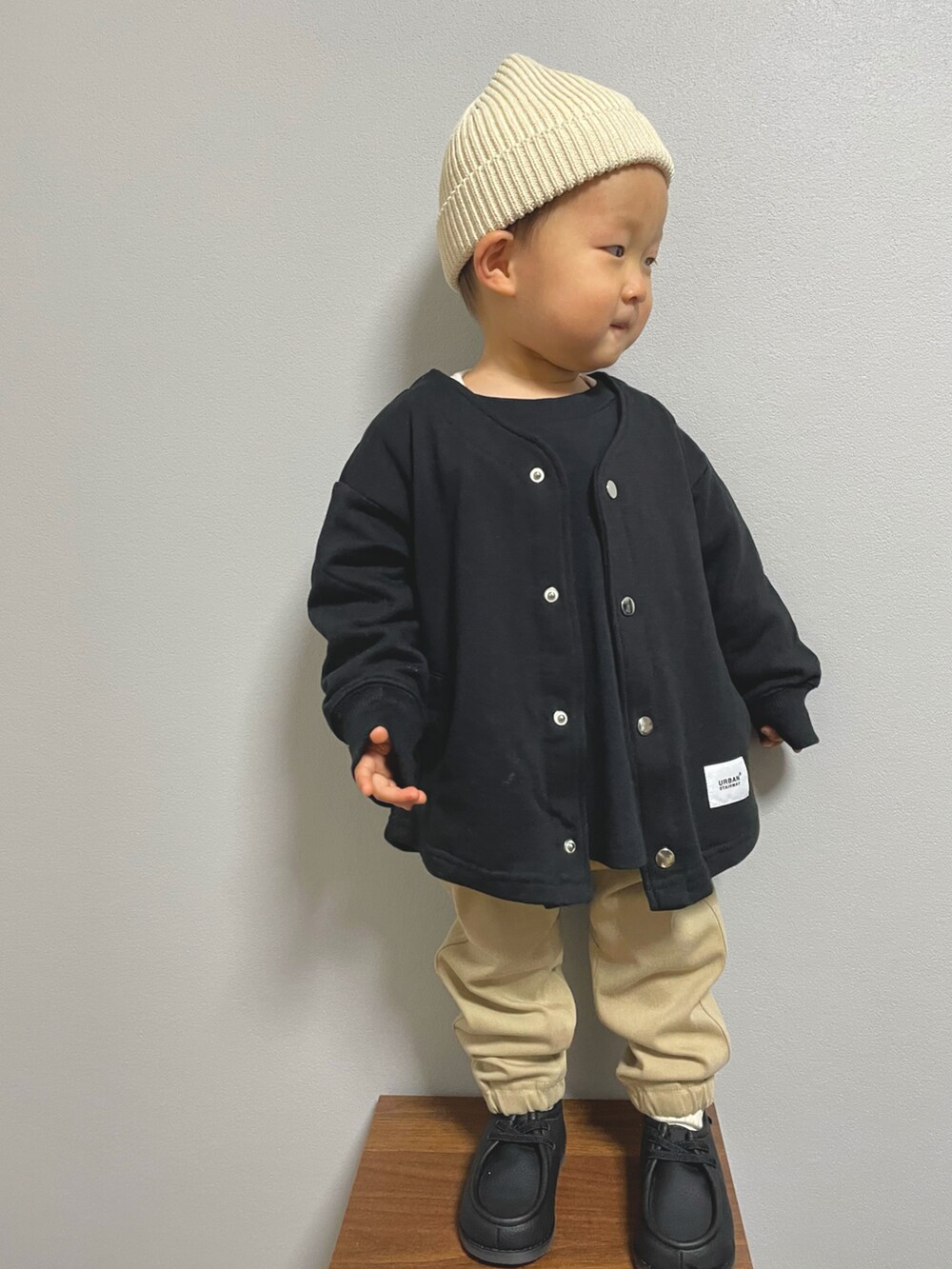 ブラック系のTシャツ/カットソー、ブラック系のノーカラージャケット、ベージュ系のパンツを着用したキッズの冬コーディネートの4枚目の写真