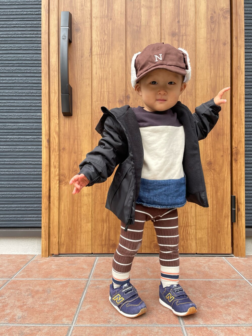 ブラック系のナイロンジャケット、ブルー系のスニーカー、グレー系のスウェットを着用したキッズの冬コーディネートの2枚目の写真