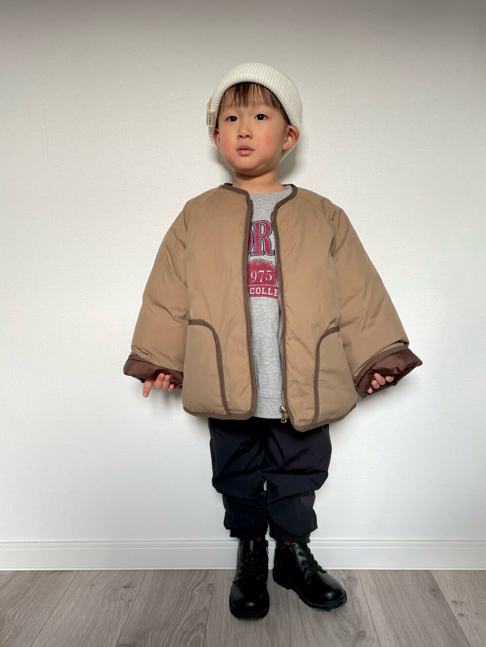 ブラウン系のノーカラージャケット、グレー系のスウェット、ブラック系のその他パンツを着用したキッズの冬コーディネートの3枚目の写真