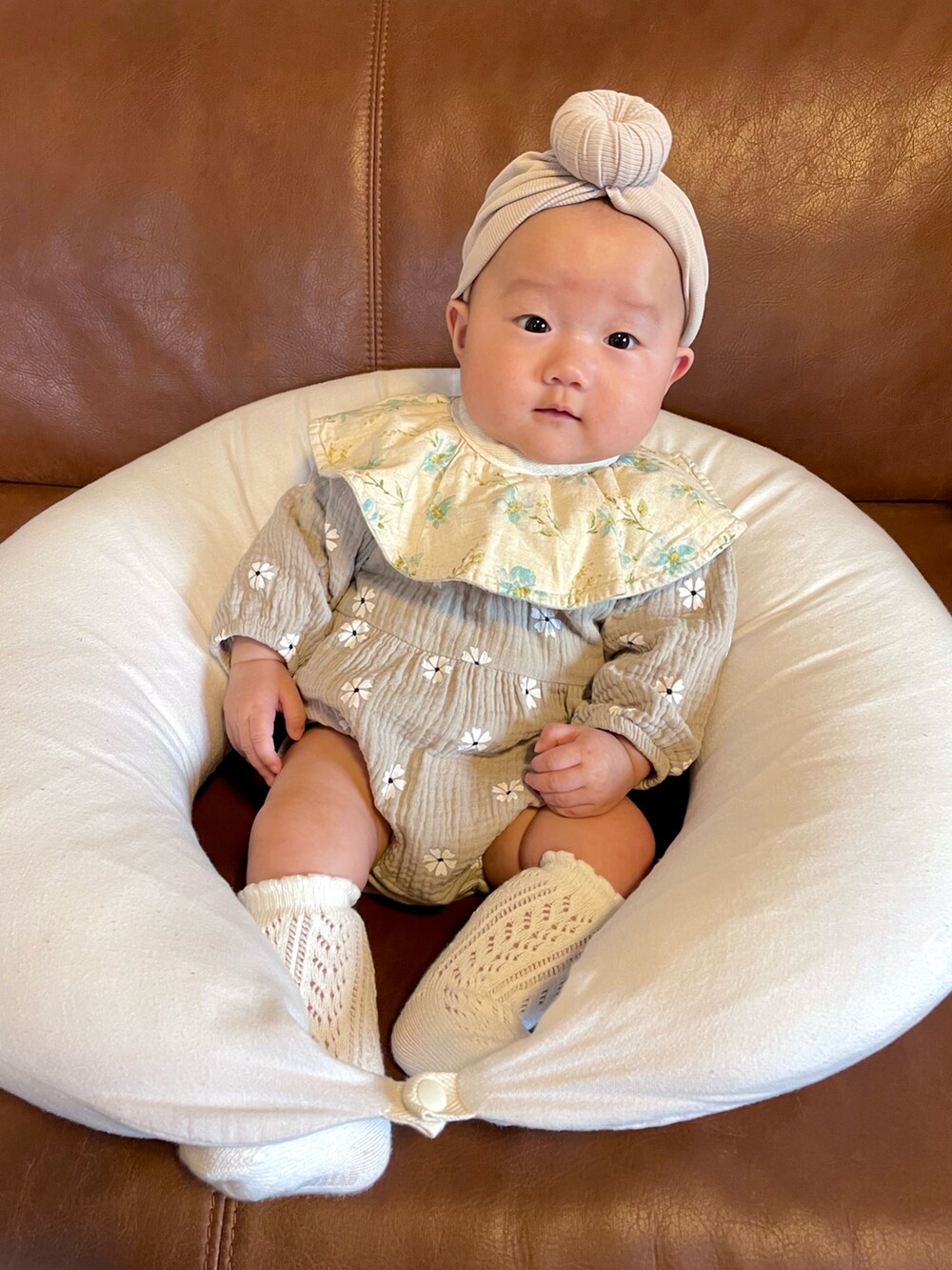 ベージュ系の帽子、グレー系のロンパース、ホワイト系のソックス/靴下を着用したキッズの秋コーディネートの2枚目の写真