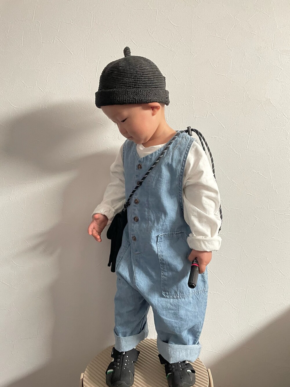 ブラック系のショルダーバッグ、ホワイト系のTシャツ/カットソー、ブルー系のサロペット/オーバーオールを着用したキッズの春コーディネートの3枚目の写真