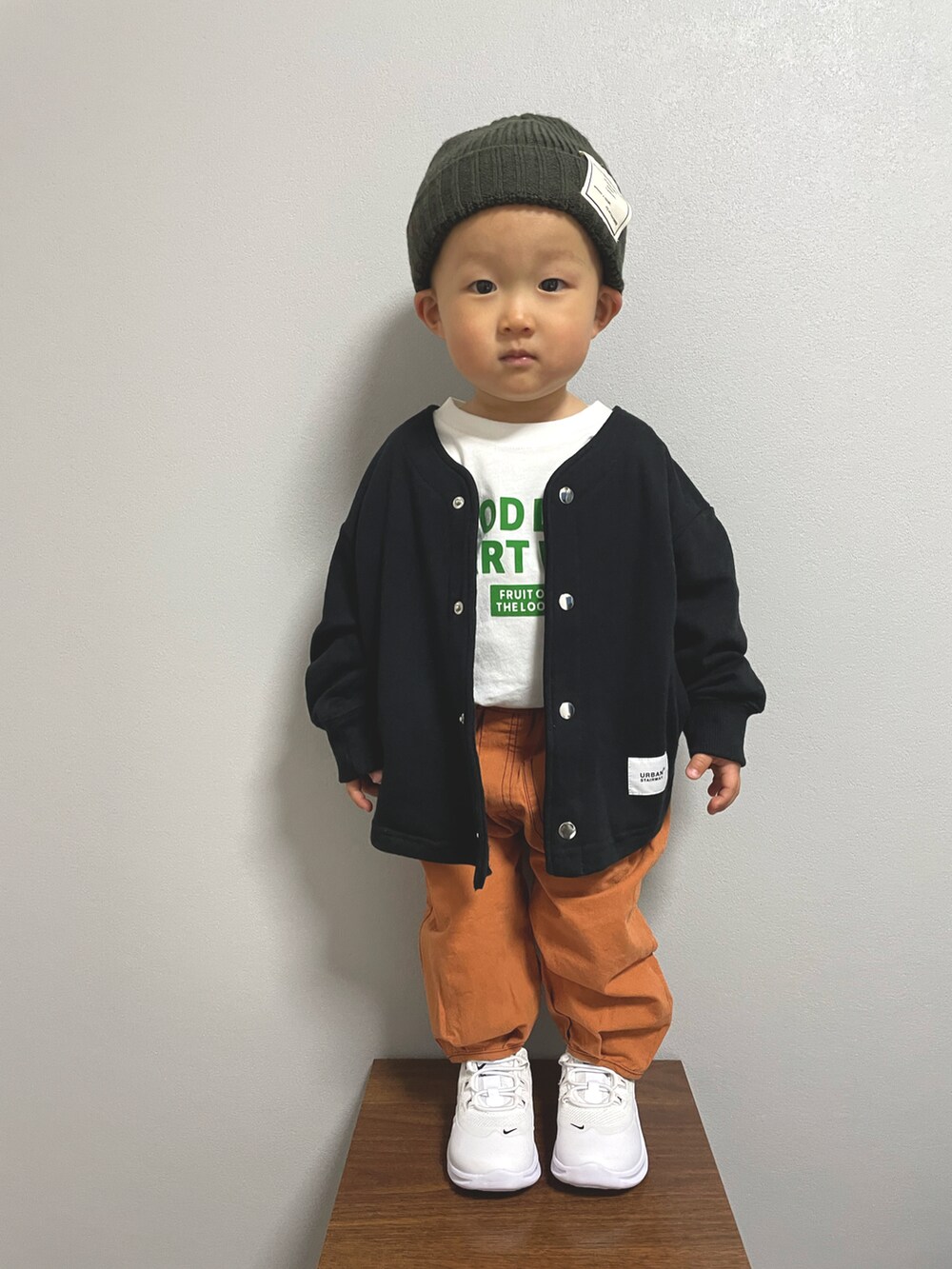 ホワイト系のTシャツ/カットソー、ブラック系のノーカラージャケット、ホワイト系のスニーカーを着用したキッズの冬コーディネートの3枚目の写真