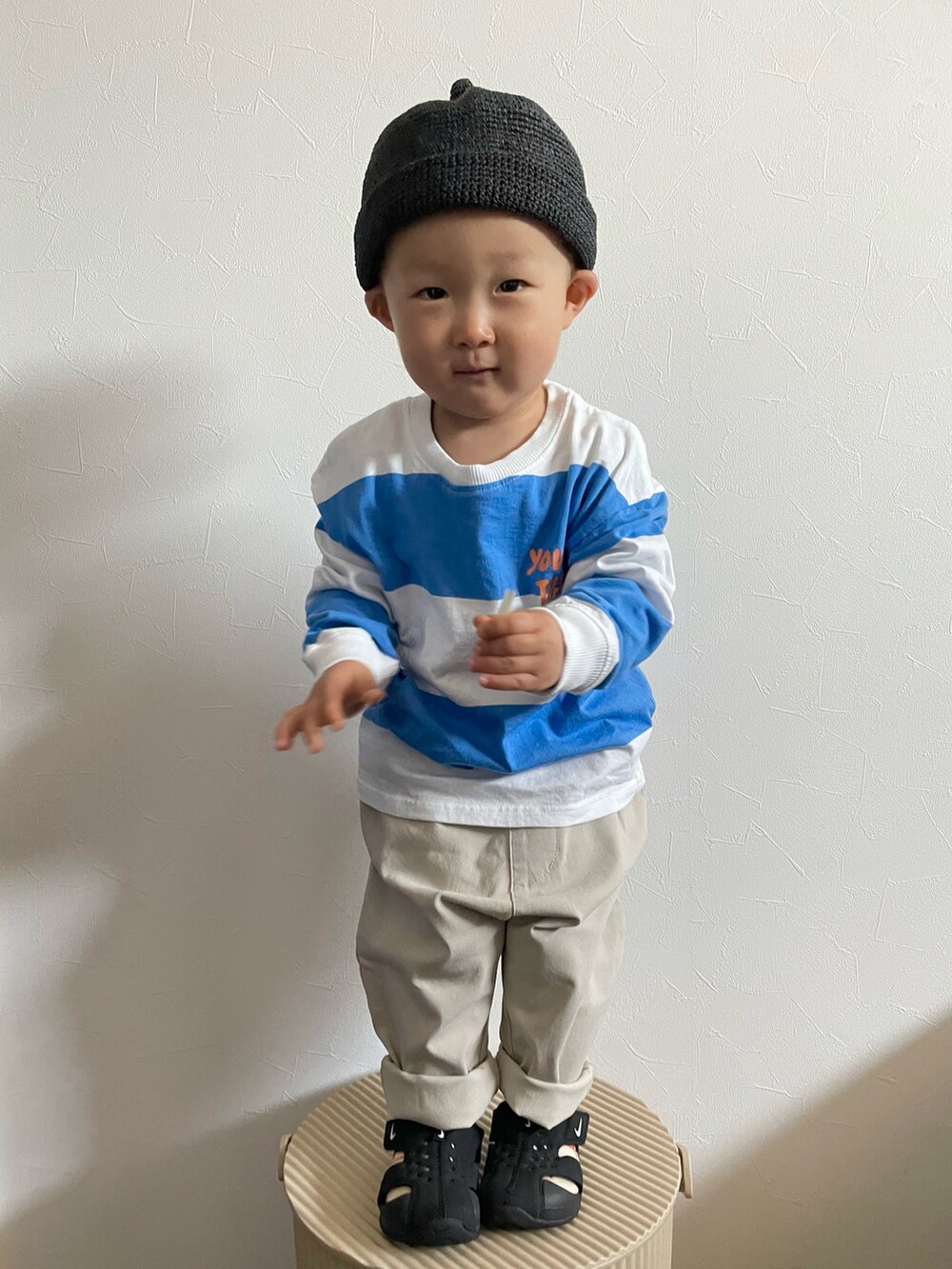 ホワイト系のTシャツ/カットソー、ブラック系のサンダル、ブラック系のキャップを着用したキッズの春コーディネートの5枚目の写真