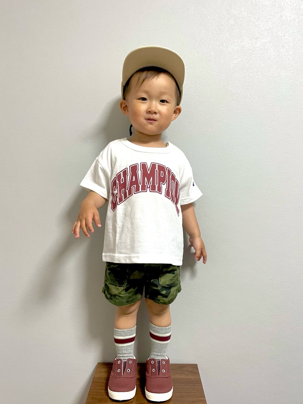 グリーン系のカーゴパンツ、レッド系のスニーカー、ベージュ系のキャップを着用したキッズの春コーディネートの4枚目の写真