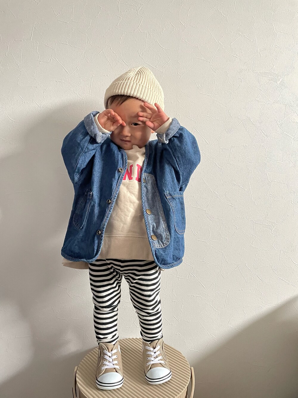 ベージュ系のスウェット、ブルー系のデニムジャケット、ベージュ系のスニーカーを着用したキッズの春コーディネートの3枚目の写真