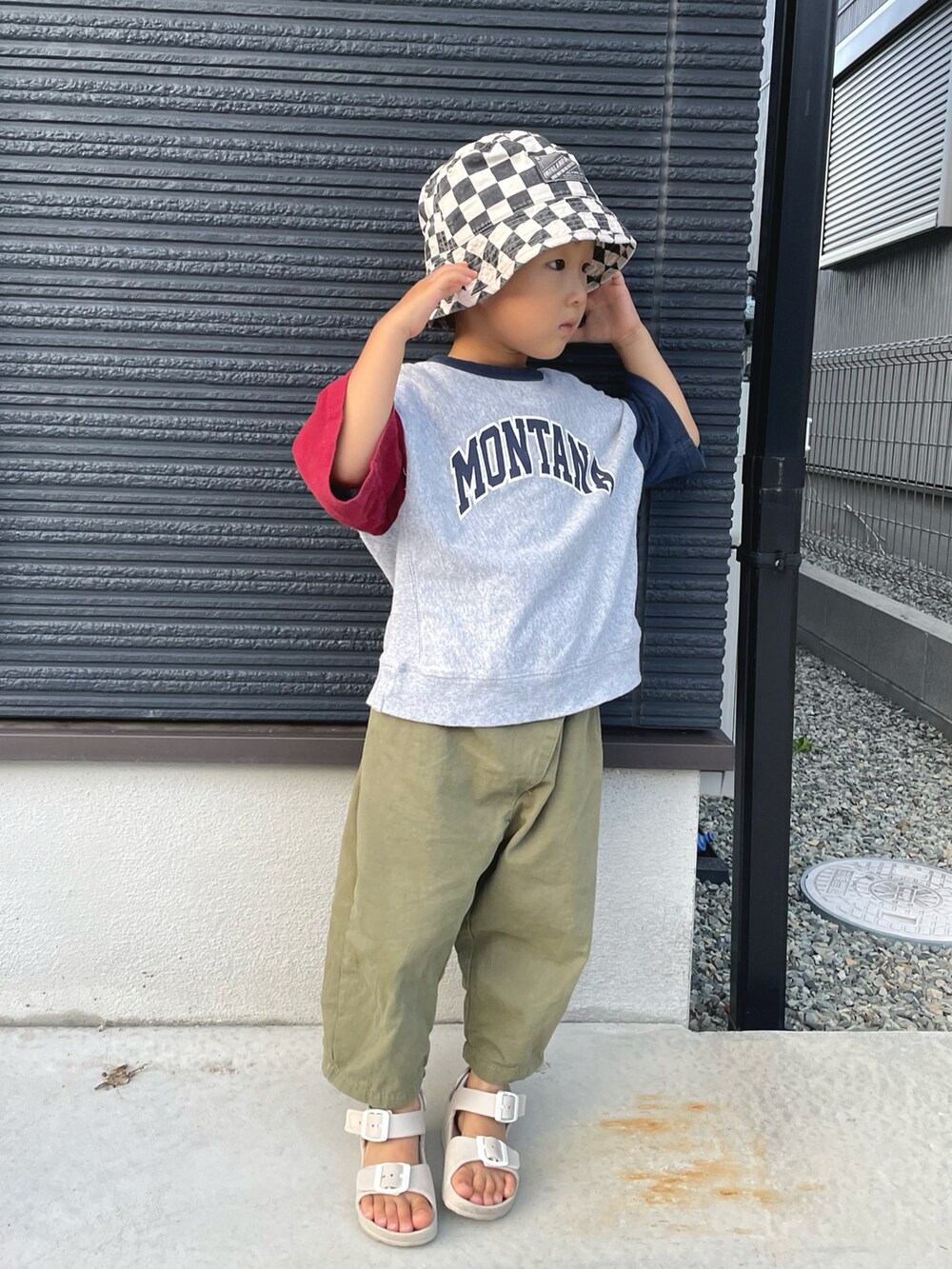 ベージュ系のサンダル、ブラック系のハットを着用したキッズの秋コーディネートの2枚目の写真