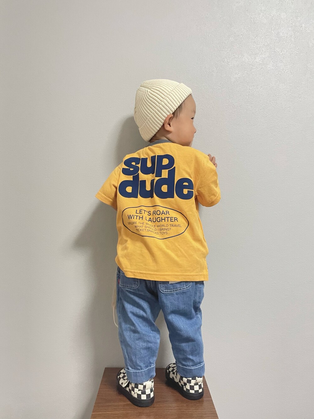 オレンジ系のTシャツ/カットソー、ブルー系のデニムパンツ、ブラック系のスリッポンを着用したキッズの春コーディネートの2枚目の写真