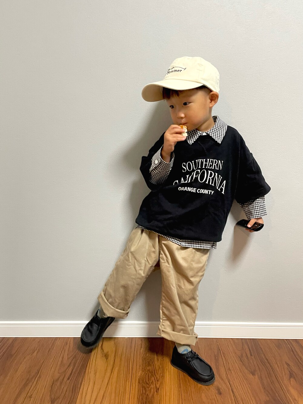 ブラック系のスウェット、ブラック系のシャツ/ブラウス、ベージュ系のチノパンツを着用したキッズの秋コーディネートの2枚目の写真