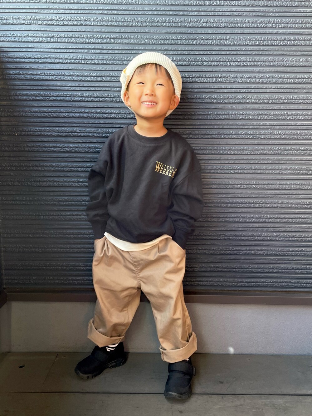 ブラック系のスニーカー、ブラック系のスウェット、ベージュ系のチノパンツを着用したキッズの秋コーディネートの3枚目の写真