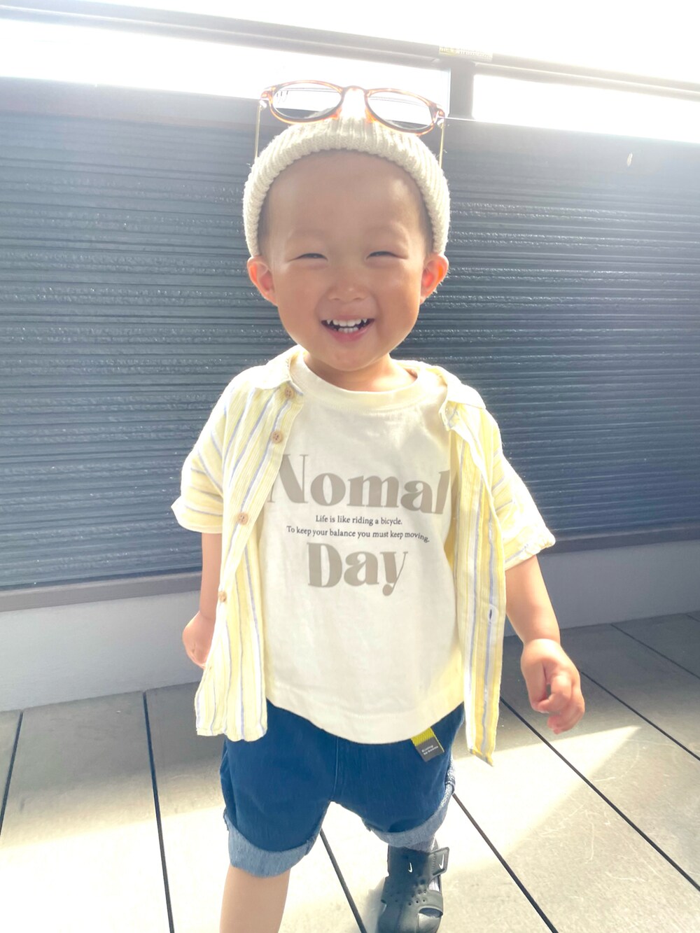 ベージュ系のTシャツ/カットソー、イエロー系のシャツ/ブラウス、ブルー系のデニムパンツを着用したキッズの春コーディネートの4枚目の写真