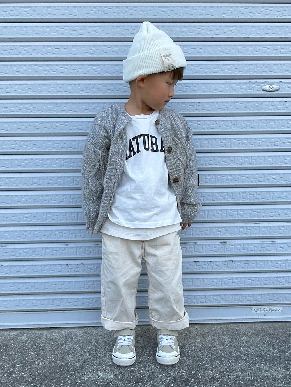 ホワイト系のTシャツ/カットソー、グレー系のカーディガン/ボレロ、ホワイト系のデニムパンツを着用したキッズの秋コーディネートの2枚目の写真