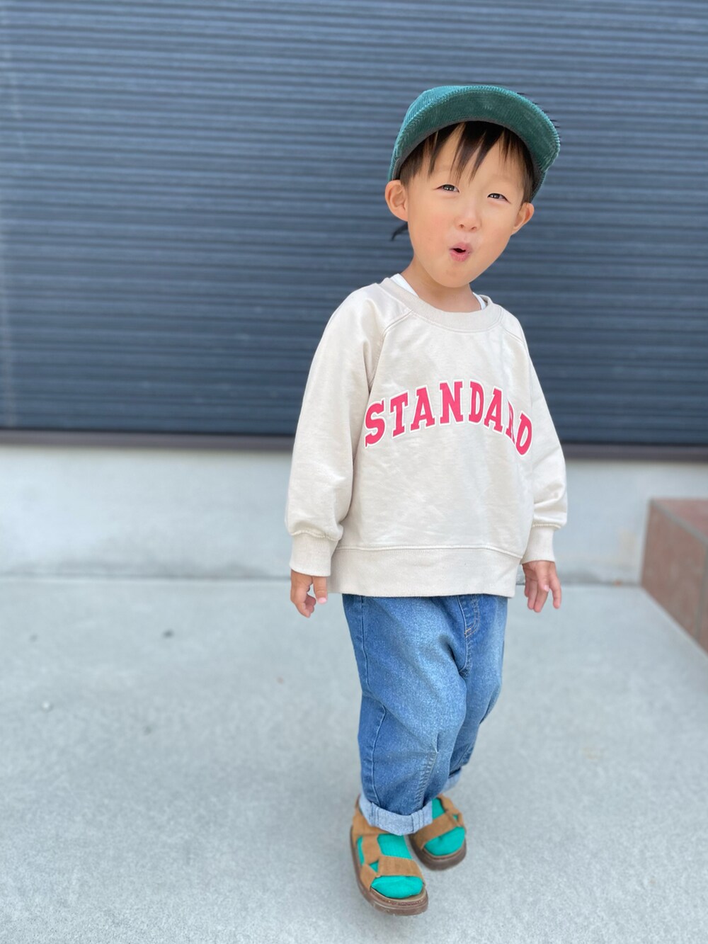 ベージュ系のスウェット、ブルー系のデニムパンツ、ブラウン系のサンダルを着用したキッズの春コーディネートの4枚目の写真