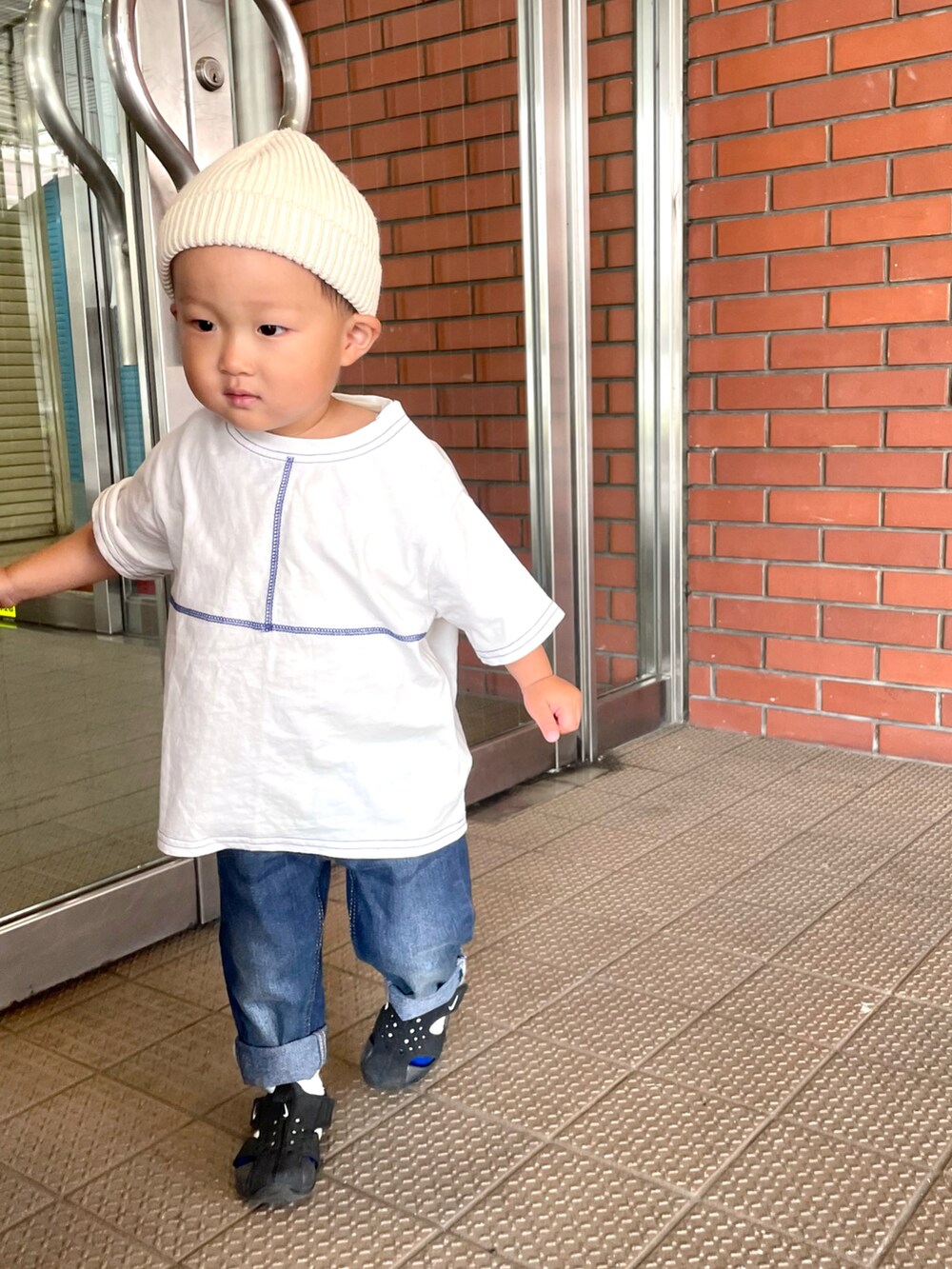 ブラック系のノーカラージャケット、ホワイト系のTシャツ/カットソー、ブルー系のデニムパンツを着用したキッズの春コーディネートの3枚目の写真