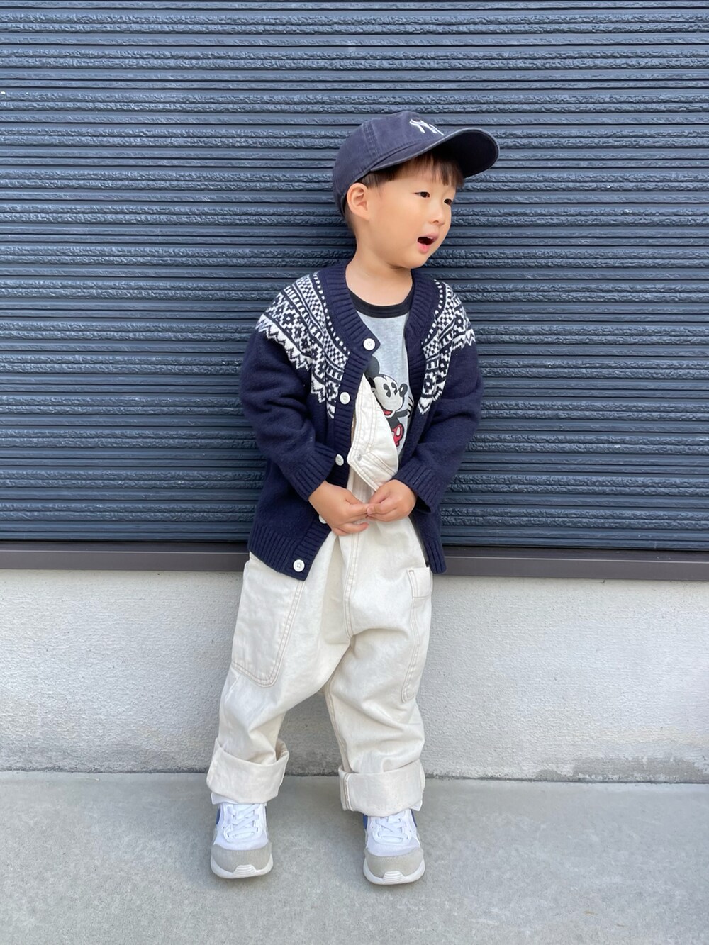 グレー系のTシャツ/カットソー、ブルー系のカーディガン/ボレロ、ホワイト系のサロペット/オーバーオールを着用したキッズの秋コーディネートの2枚目の写真