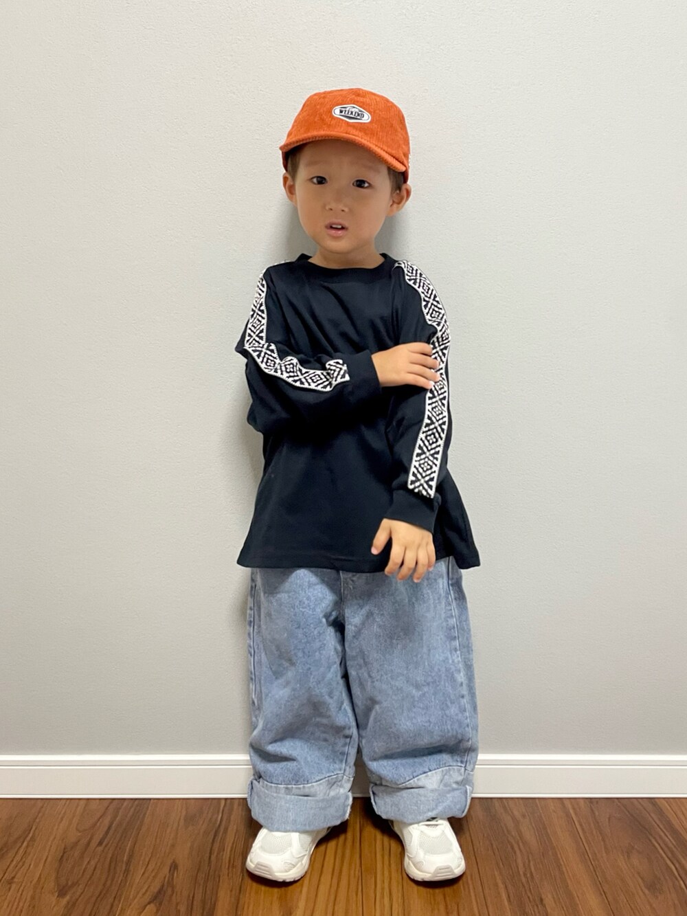 ブラック系のTシャツ/カットソー、ブルー系のデニムパンツ、ホワイト系のスニーカーを着用したキッズの秋コーディネートの3枚目の写真