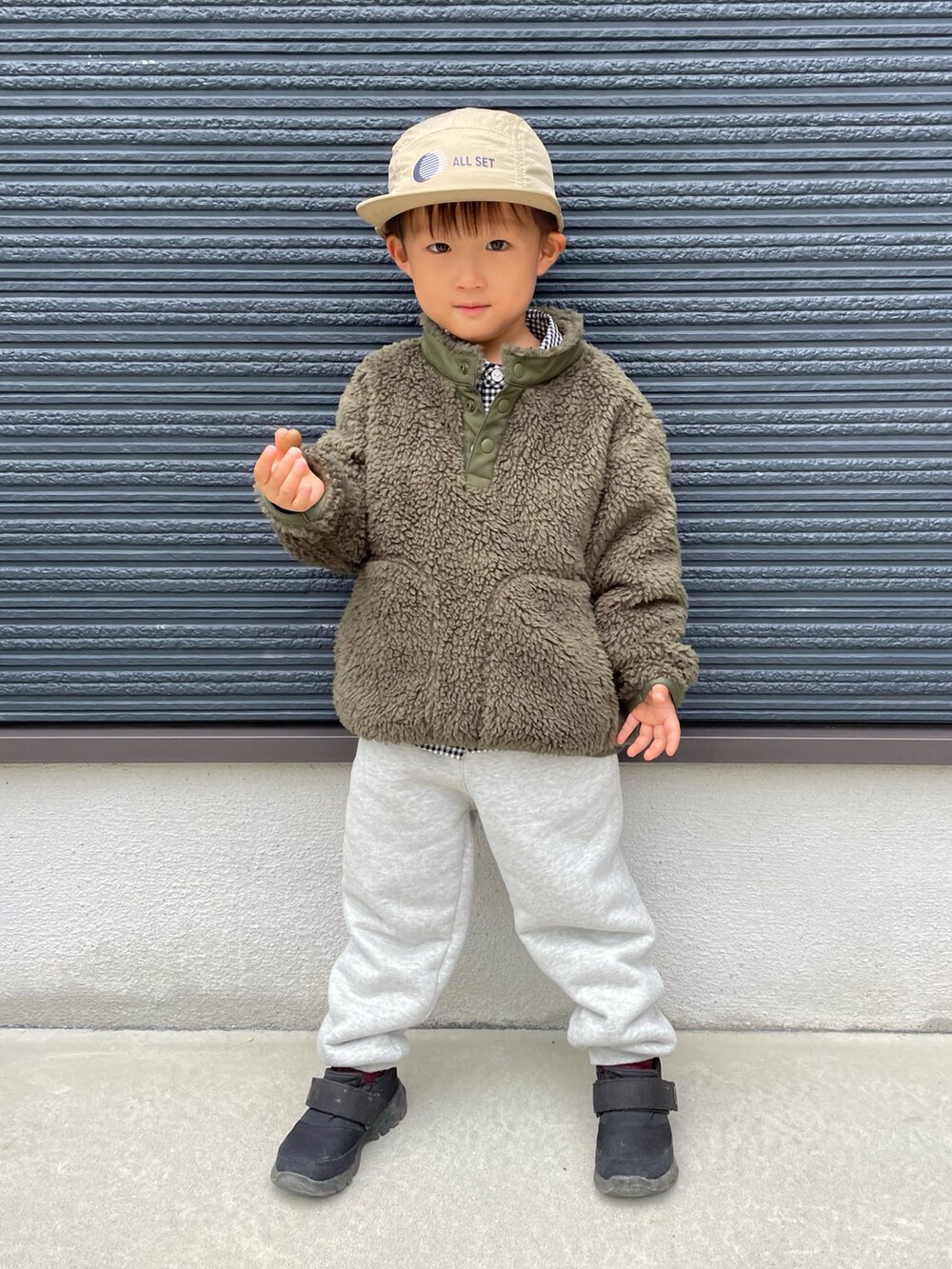 グリーン系のブルゾン、ブラック系のシャツ/ブラウス、ブラック系のスニーカーを着用したキッズの秋コーディネートの4枚目の写真