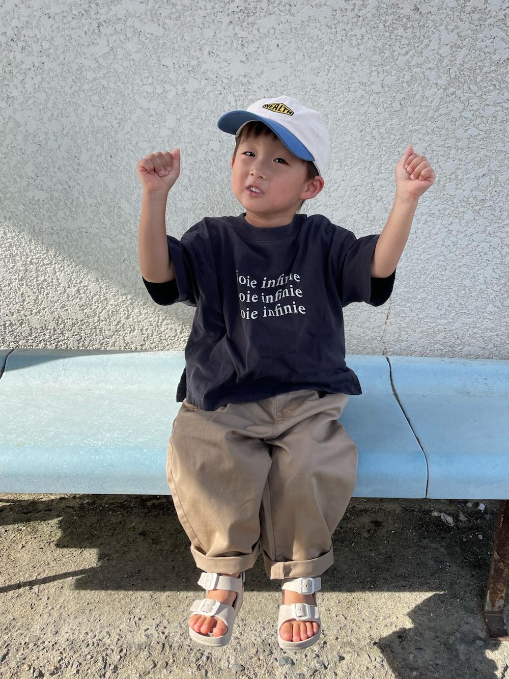 グレー系のTシャツ/カットソー、ベージュ系のチノパンツ、ベージュ系のサンダルを着用したキッズの夏コーディネートの3枚目の写真