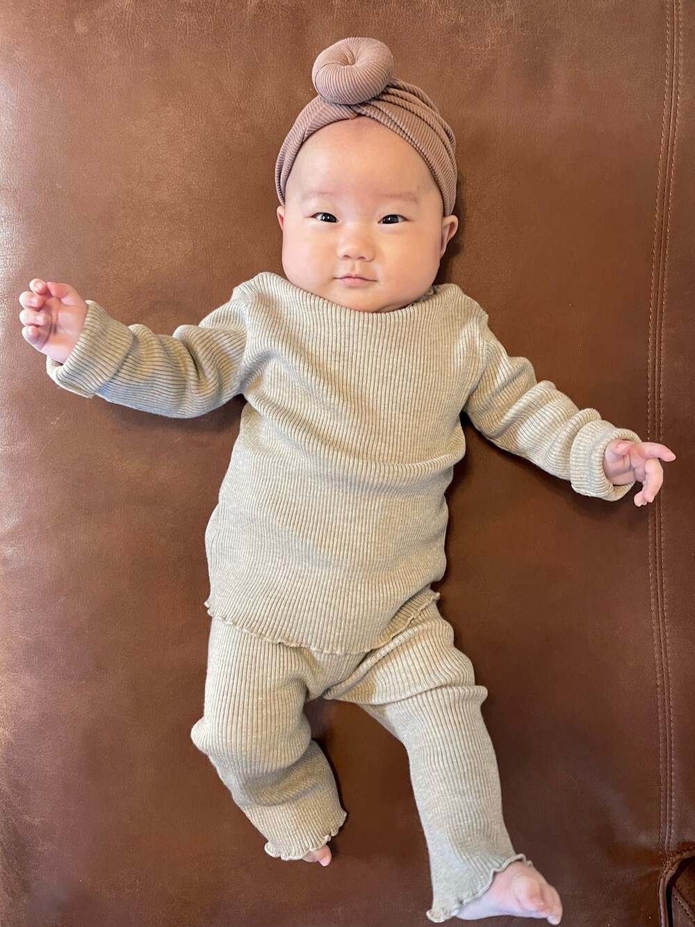 ベージュ系のセットアップ、ブラウン系のヘアバンドを着用したキッズの秋コーディネートの3枚目の写真